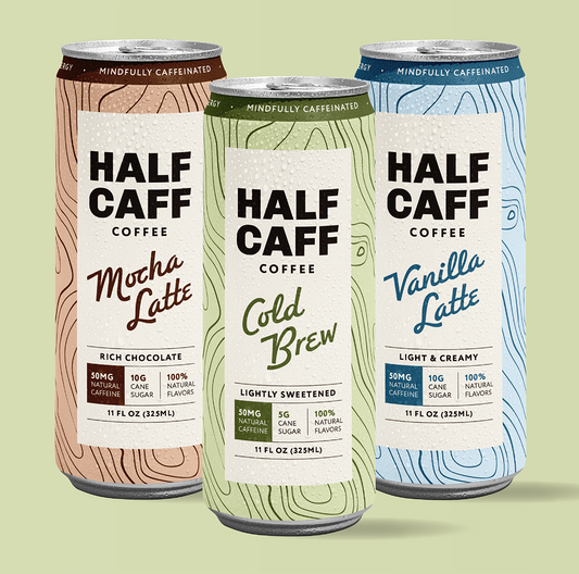 Variety pack of half-caffeinated canned coffee ready to drink for half-caff coffee with three flavors shown, half-caff cold brew, half-caff mocha latte, and half-caff vanilla latte, all with 50 milligrams of caffeine and low sugar