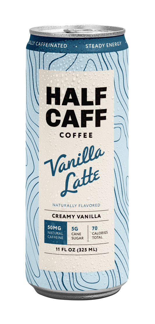 A 11 fl oz can of Half Caff Coffee Vanilla Latte, featuring a light blue and white topographic pattern with a cream-colored central label.